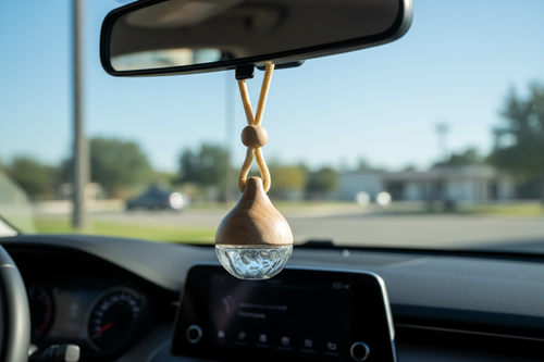Glass car diffuser hanging from rearview mirror